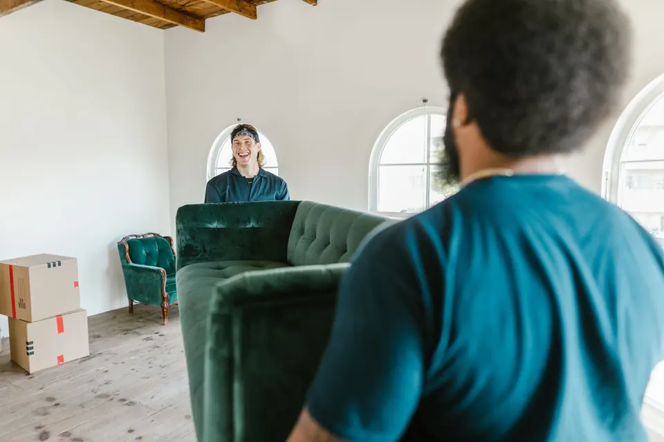Privatumzug Villach in Villach: Sofa wird gemeinsam durch einen Zugang getragen
